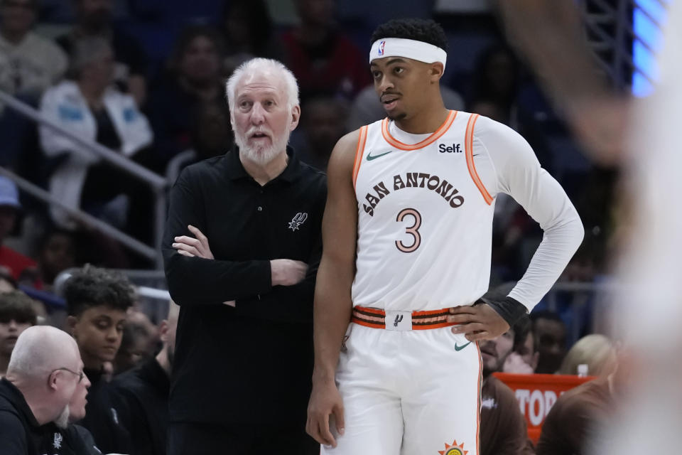 San Antonio Spurs head coach Gregg Popovich talks with forward Keldon Johnson (3) in the first half of an NBA basketball game against the New Orleans Pelicans in New Orleans, Friday, Dec. 1, 2023. (AP Photo/Gerald Herbert)