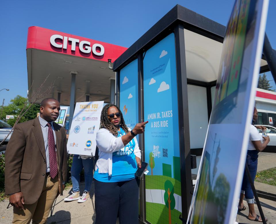 Director of the City of Milwaukee Office of Early Childhood Initiatives Dea Wright shows Mayor Cavalier Johnson the first bus shelter mural Tuesday.