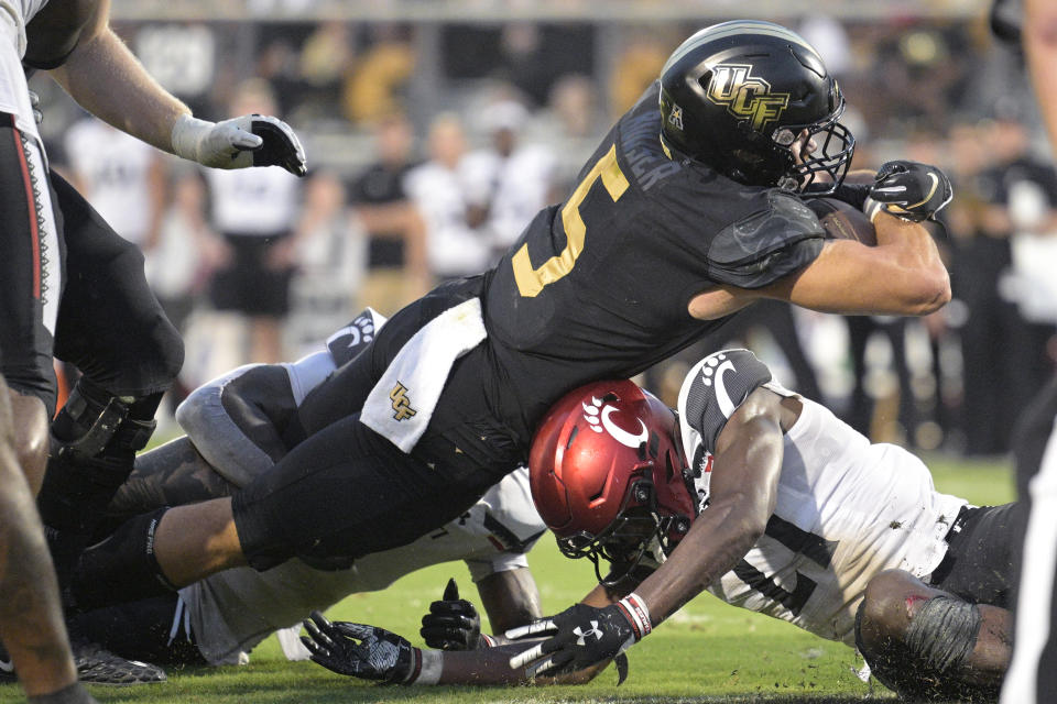 Central Florida running back Isaiah Bowser (5) scores a touchdown on a 3-yard run over Cincinnati safety Armorion Smith (27) during the second half of an NCAA college football game, Saturday, Oct. 29, 2022, in Orlando, Fla. (AP Photo/Phelan M. Ebenhack)