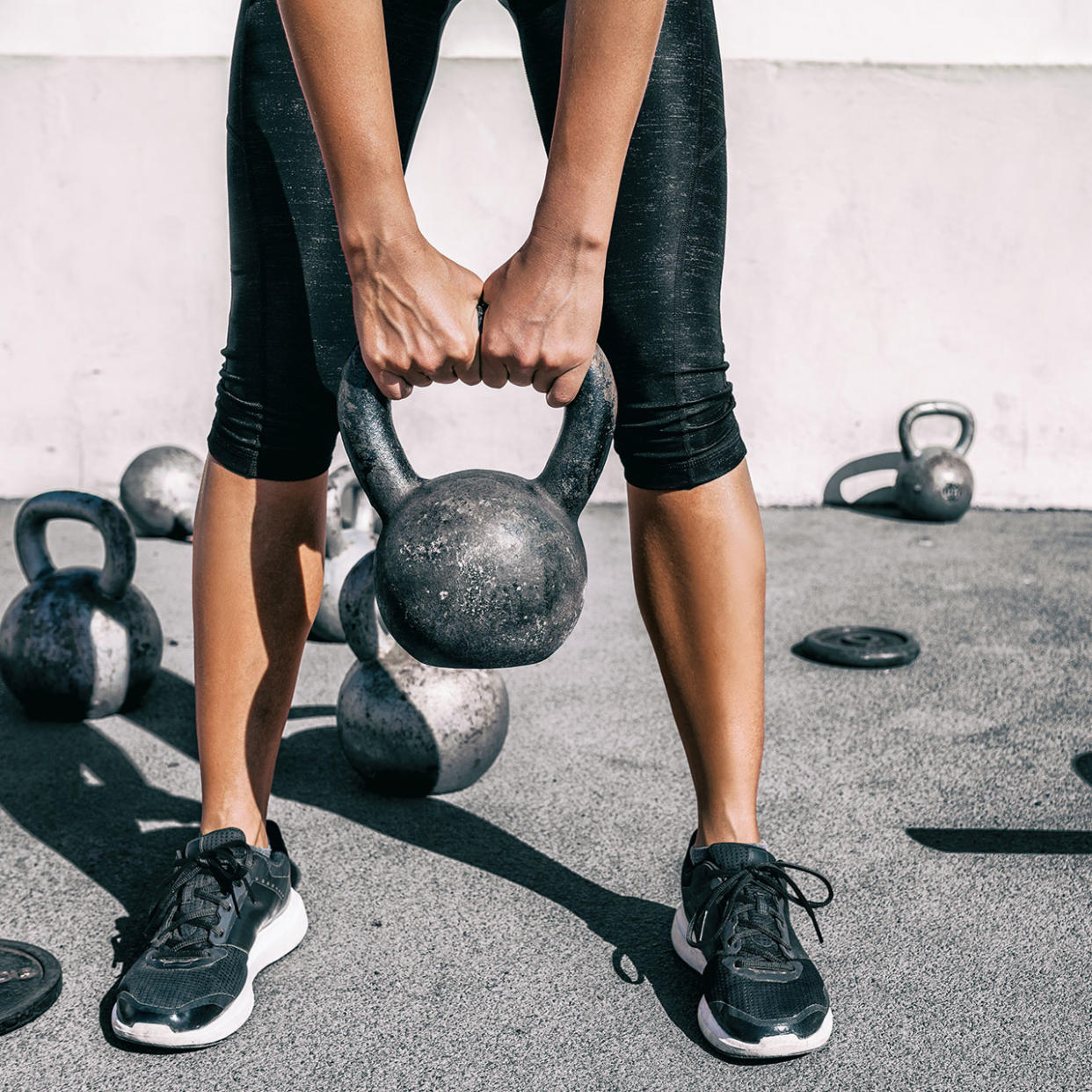 woman weight training with kettle bells