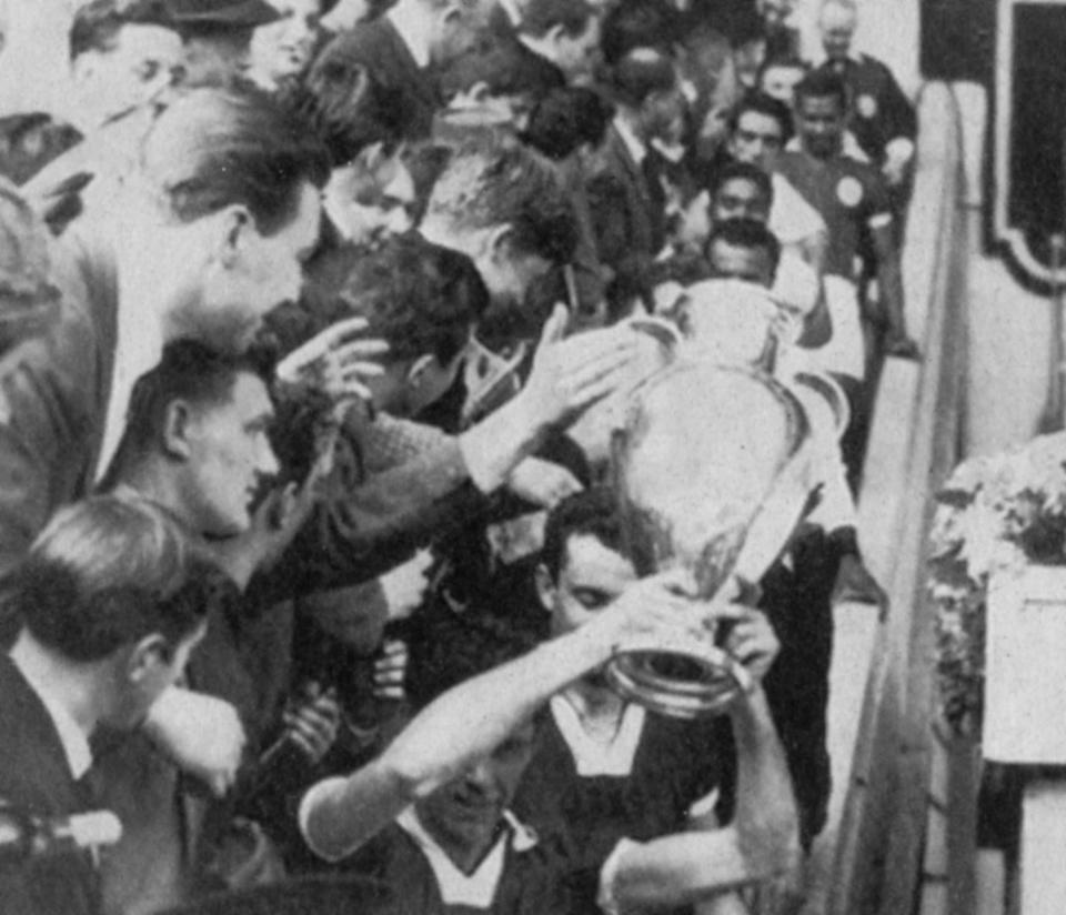 FILE - In this May 22,1963 file photo, AC Milan soccer team captain Cesare Maldini, bottom right, lifts the European Cup after AC Milan defeated Benfica 2-1 in the final at Wembley Stadium in London. A is for AC Milan, the first Italian winners of the trophy. In the absence of the Champions League final on Saturday, The Associated Press will take a look back at some of the greatest teams, players and matches in the history of the tournament. The AP will pick a topic for every letter of the alphabet to remember the greats of the game and the greatest games, going back to when the competition was called the European Cup and through its transformation into the Champions League. (AP Photo, File)