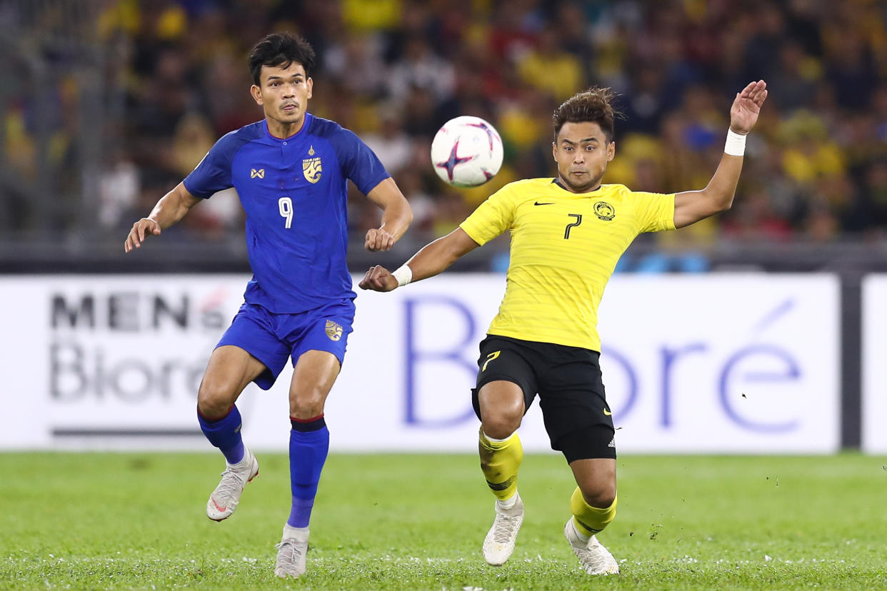 Malaysia defender Aidil Zafuan (right) battles for the batll with Thailand's Adisak Kraisorn at the 2018 AFF Suzuki Cup semi-finals. 