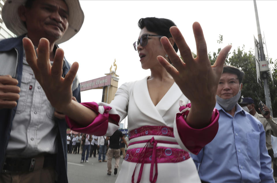 Theary Seng, center, a Cambodian-American lawyer gestures as she enters the Phnom Penh Municipal Court, in Phnom Penh, Cambodia, Thursday, Nov. 26, 2020. A Cambodian court on Thursday began hearing the cases of nearly 130 opponents and government critics charged with treason for taking part in nonviolent political activities over the past three years, in what one of them described as a sham trial. Theary Seng, who has long been one of the most outspoken critics of Hun Sen and his government, is one of the best known defendants living in Cambodia.(AP Photo/Heng Sinith)