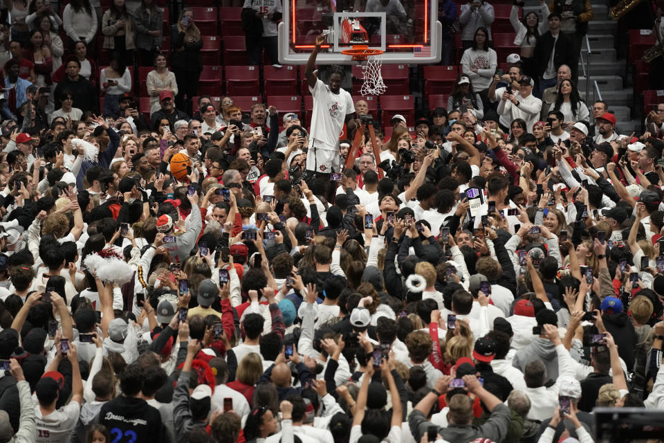 San Diego State forward Nathan Mensah, above, reacts as he cuts down the net after San Diego State defeated Wyoming in an NCAA college basketball game to win the Mountain West Conference Saturday, March 4, 2023, in San Diego. (AP Photo/Gregory Bull)