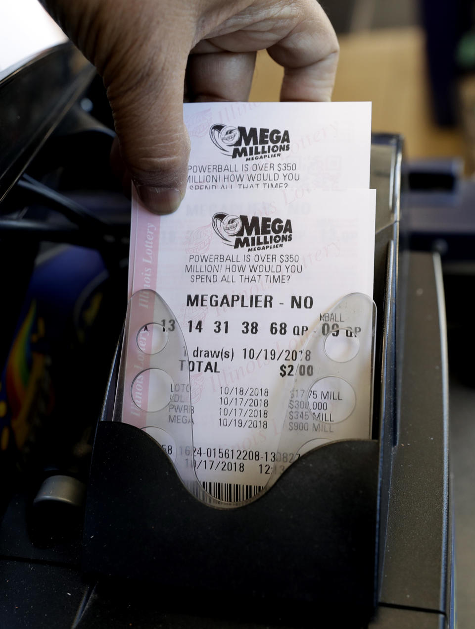 Mega Millions lottery tickets are printed out of a lottery machine at a convenience store Wednesday, Oct. 17, 2018, in Chicago. The estimated jackpot for Friday's drawing would be the second-largest lottery prize in U.S. history with a jackpot estimated to exceed $900 million. (AP Photo/Nam Y. Huh)