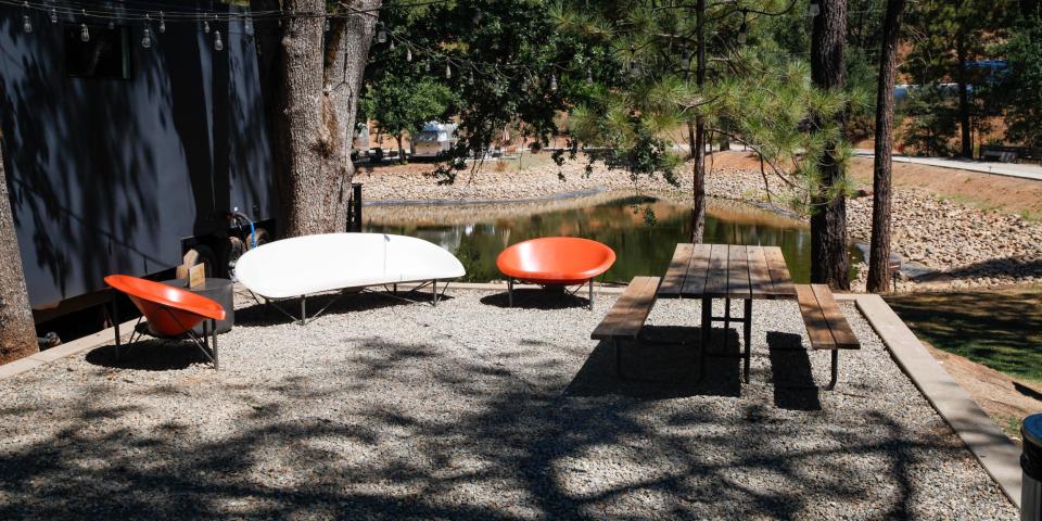 A seating area by one of the cabins under the shade