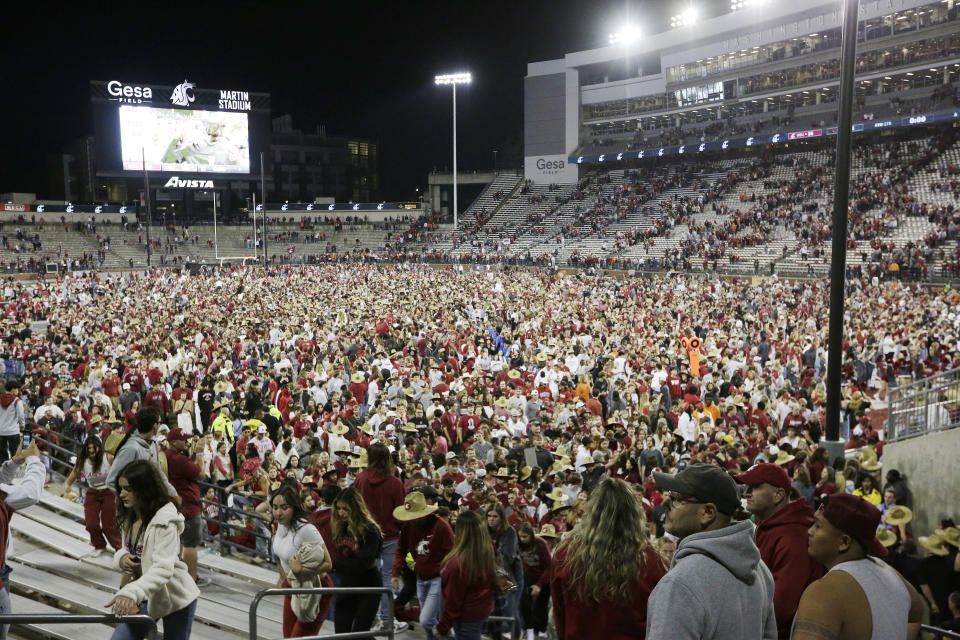 Washington State fans and players celebrate on the field after the team won an NCAA college football game against Oregon State 38-35, Saturday, Sept. 23, 2023, in Pullman, Wash. (AP Photo/Young Kwak)