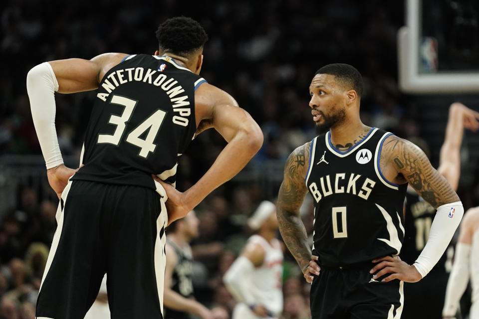 Milwaukee Bucks' Damian Lillard (0) talks with Giannis Antetokounmpo (34) during the first half of an NBA basketball game against the New York Knicks Sunday, April 7, 2024, in Milwaukee. (AP Photo/Aaron Gash)