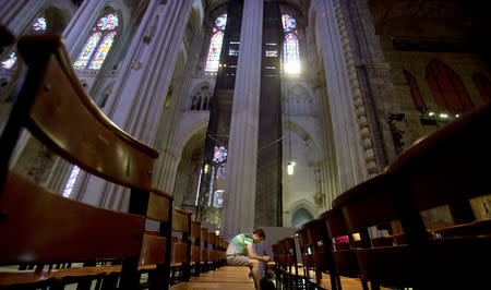 FILE PHOTO: A man sits in the pews of Cathedral of St. John the Divine in New York, June 25, 2013. REUTERS/Carlo Allegri/File Photo