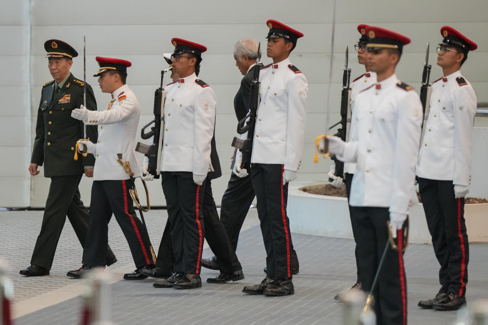 Chinese Defense Minister Gen. Li Shangfu, left, inspects honor guard with Singapore Defense Minister Ng Eng Hen, behind, during his official visit to the defense ministry in Singapore, Thursday, June 1, 2023. China and Singapore laid the groundwork Friday for a hotline between the two countries that would establish a high-level communications link between Beijing and a close American partner in Asia at a time when Chinese tensions with Washington are high and dialogue has stalled. (AP Photo/Vincent Thian)