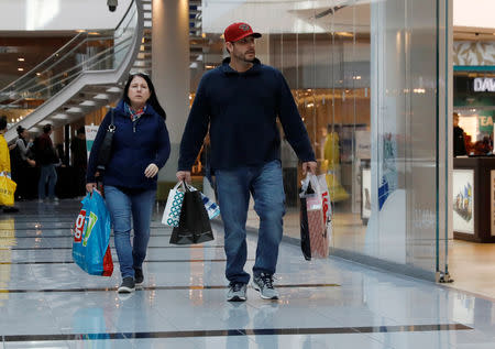 FILE PHOTO: People walk with shopping bags at Roosevelt Field mall in Garden City, New York, U.S., December 7, 2018. REUTERS/Shannon Stapleton