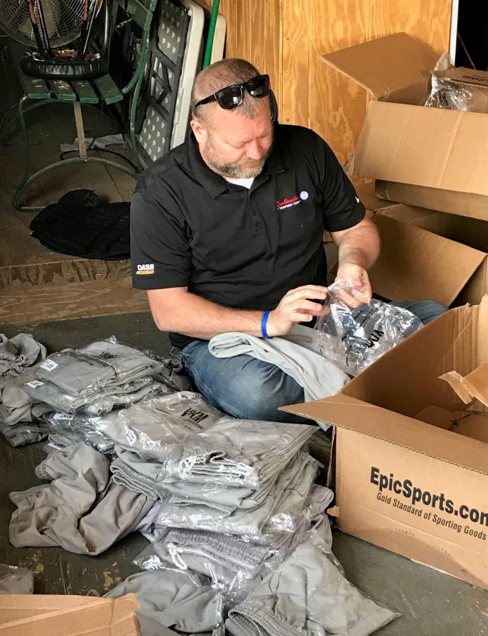 Cambridge Little League president Travis Daugherty sorts baseball pants in preparation for the season. The Cambridge Little League will hold its Opening Day Celebration on Saturday.