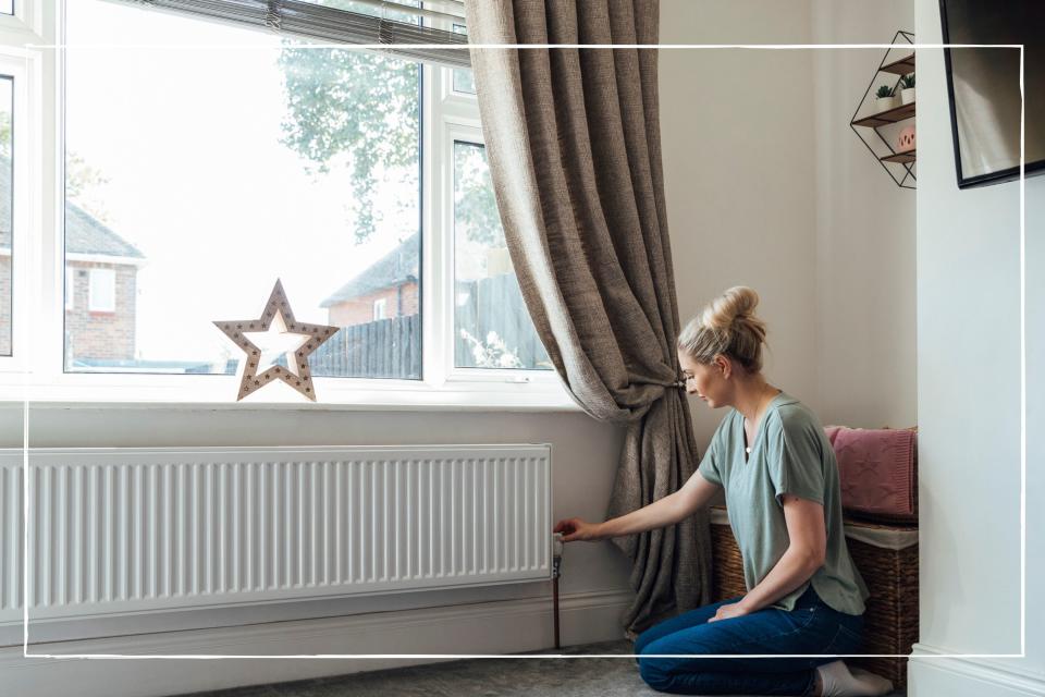 woman adjusting the valve on a radiator at home