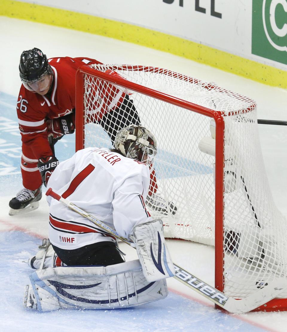 Canada's Curtis Lazar (L) scores on Switzerland's goalie Melvin Nyffeler during the third period of their IIHF World Junior Championship ice hockey game in Malmo, Sweden, January 2, 2014. REUTERS/Alexander Demianchuk (SWEDEN - Tags: SPORT ICE HOCKEY)