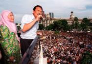 FILE PHOTO: Sacked Malaysian finance minister Anwar Ibrahim speaks to a crowd of over 30,000 supporters at the national mosque with his wife Wan Azizah beside him in Kuala Lumpur