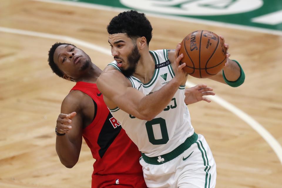 Boston Celtics' Jayson Tatum (0) drives past Toronto Raptors' Kyle Lowry during the first half of an NBA basketball game, Thursday, Feb. 11, 2021, in Boston. (AP Photo/Michael Dwyer)