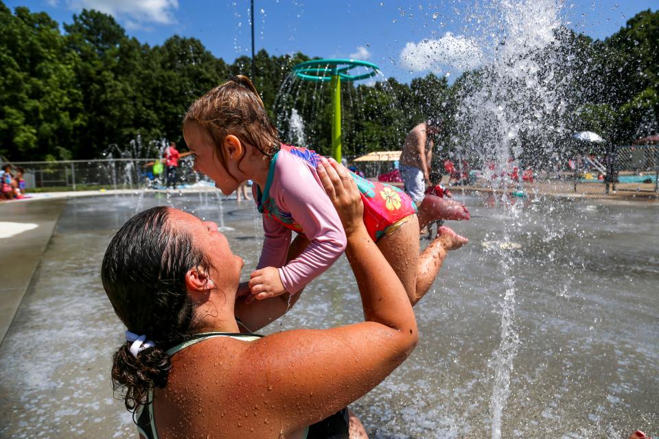 Ashley Whitlow lifts up her daughter Emersyn Whitlow, 2, while the two play in the water spot area on an especially hot day when a heat wave is sweeping across the U.S. at Swan Lake Pool in Clarksville, Tenn., on Saturday, July 20, 2019. 