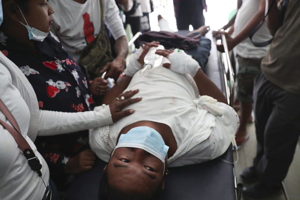 An injured protester is tended to during a demonstration against the military coup in Mandalay, Myanmar, Friday, Feb. 26, 2021. Security forces in Myanmar's largest city on Friday fired warning shots and beat truncheons against their shields while moving to disperse more than 1,000 anti-coup protesters. (AP Photo)