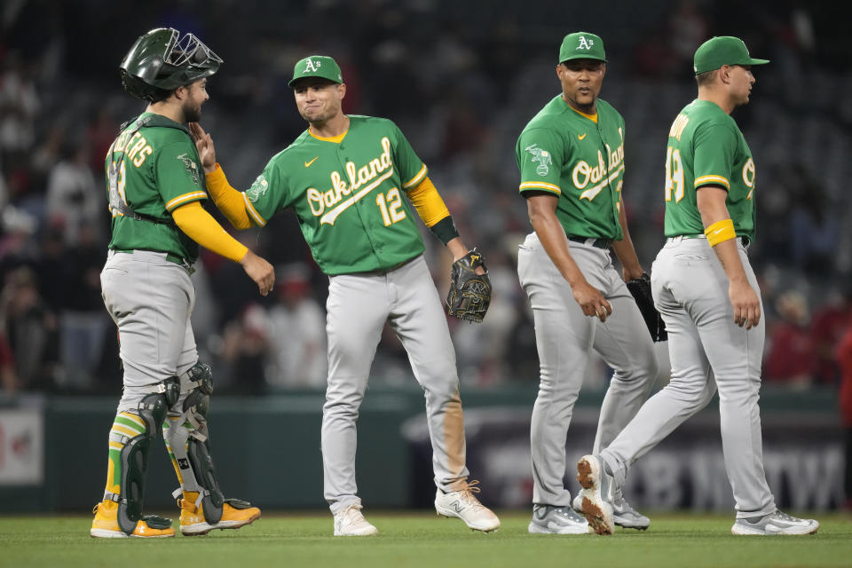 Oakland Athletics catcher Shea Langeliers (23), third baseman Aledmys Diaz (12), relief pitcher Jeurys Familia (31), and first baseman Ryan Noda (49) celebrate after an 11-10 win over the Los Angeles Angels in a baseball game in Anaheim, Calif., Monday, April 24, 2023. (AP Photo/Ashley Landis)