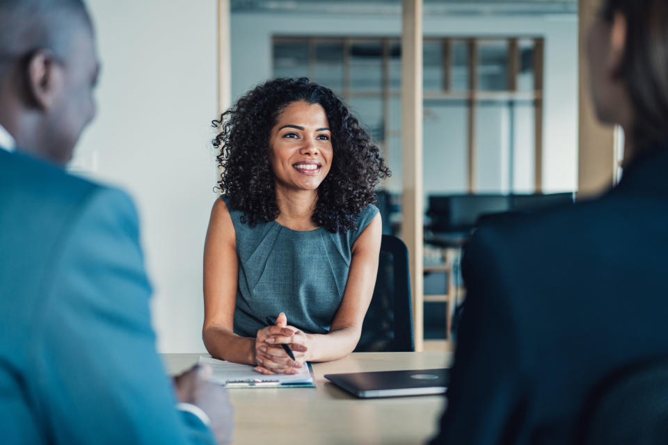 person in a meeting sitting across two others