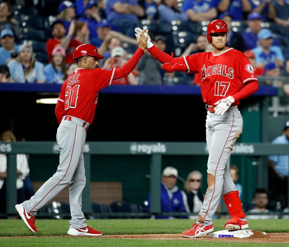 Los Angeles Angels' Shohei Ohtani, right, celebrates with third base coach Dino Ebel after hitting a three-run triple during the seventh inning against the Kansas City Royals on April 12, 2018, in Kansas City, Mo.