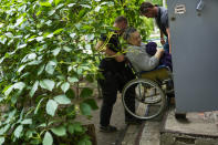 A woman is carried from her home in an evacuation by British volunteers group BEAR in Bakhmut, eastern Ukraine, Friday, May 27, 2022. Volunteers have been racing to evacuate as many civilians as possible, particularly the elderly and those with mobility issues, as Russian forces make advances in the region. (AP Photo/Francisco Seco)