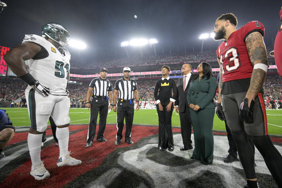 Martin Luther King Jr. III, third from right, stands with his wife, Arndrea Waters King, second from right, and their daughter, Yolanda Renee King, center right, as they serve as Tampa Bay Buccaneers honoree captains during the coin toss with Philadelphia Eagles defensive tackle Fletcher Cox (91) and Buccaneers wide receiver Mike Evans (13) prior to an NFL wild-card playoff football game, Monday, Jan. 15, 2024, in Tampa, Fla. Officials looking on are back judge Greg Steed (12), second from left, and referee Adrian Hill. (AP Photo/Phelan M. Ebenhack)