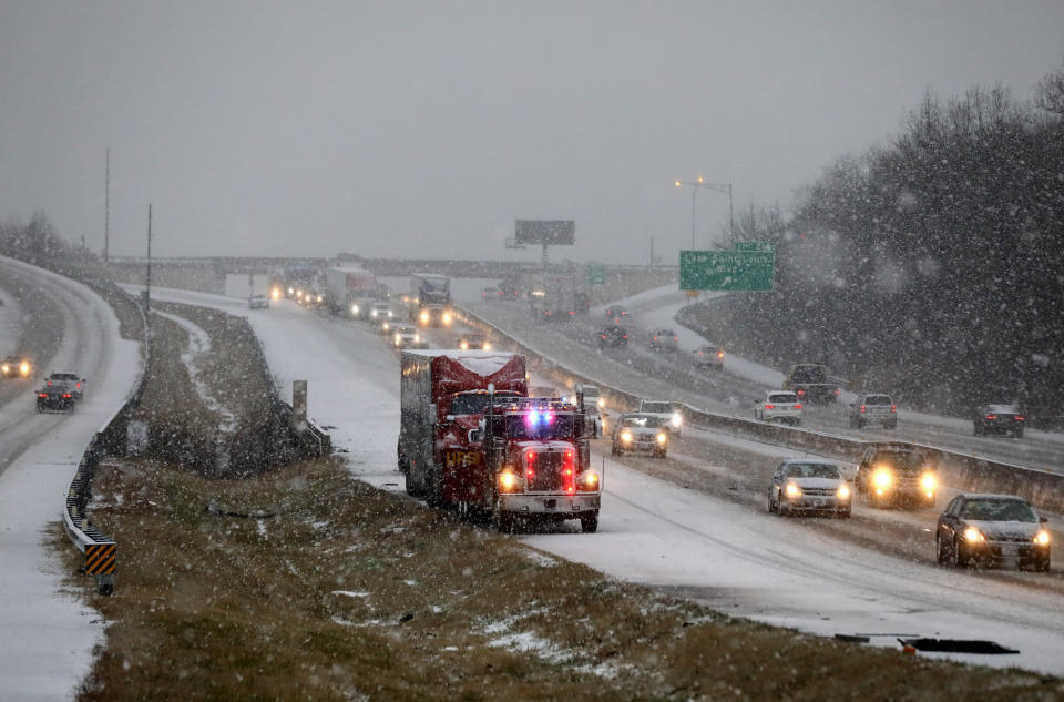 En medio de una ligera caída de nieve, una grúa arrastra un camión descompuesto para retirarlo de la interestatal 70 este en Lake St. Louis, Missouri, el sábado 11 de enero de 2020. (David Carson/St. Louis Post-Dispatch vía AP)