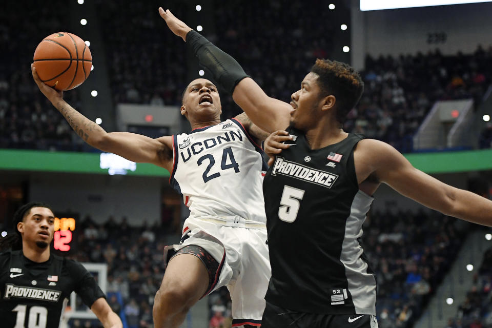 Connecticut's Jordan Hawkins (24) shoots as Providence's Ed Croswell (5) defends in the first half of an NCAA college basketball game, Saturday, Dec. 18, 2021, in Hartford, Conn. (AP Photo/Jessica Hill)