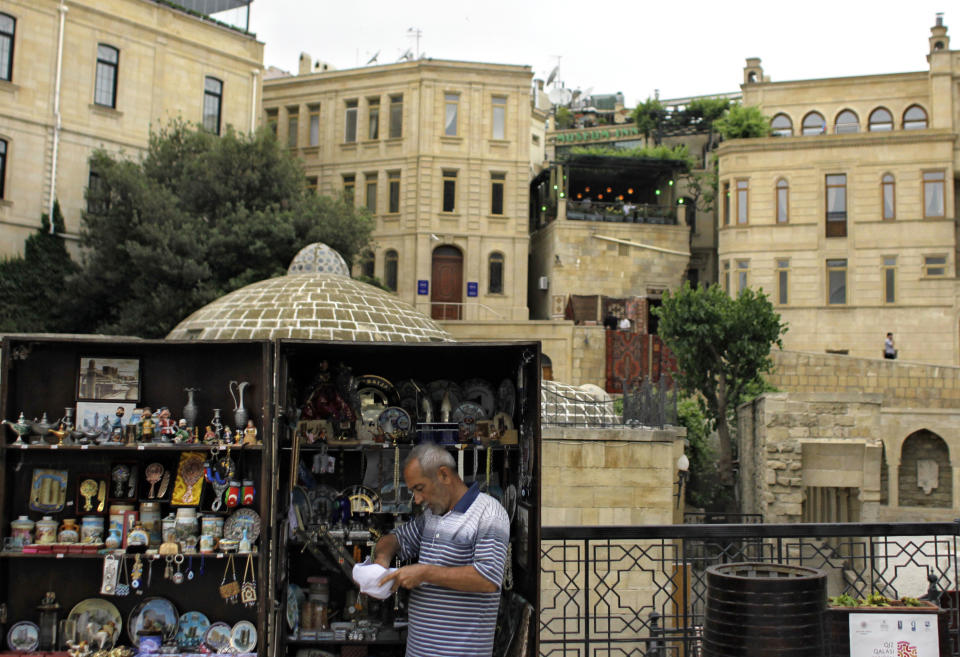 A souvenir vendor seen in his box-shop in downtown Baku, Azerbaijan, Tuesday, May 22, 2012. The capital of this former Soviet republic has shed its dour, industrial image and evolved into a vibrant metropolis combining the old world charms of Istanbul with the architectural ostentations of Dubai. Now it has the perfect stage to show off its decade-long transformation: the Eurovision Song contest. (AP Photo/Sergey Ponomarev)