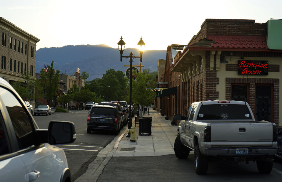 In this June 30, 2021 photo, the sun sets at the front of the town of Minden, Nev. Efforts to silence the century-old siren that blares every night at 6 p.m. are sparking debates over how to confront the region's history of racism and violence. The Washoe Tribe of Nevada and California associates the siren with a historic "sundown ordinance" that once made it illegal for them to be in Minden and neighboring Gardnerville after nightfall. Residents of the mostly white town defend it as a tradition that marks time and honors first responders. (AP Photo/Sam Metz)