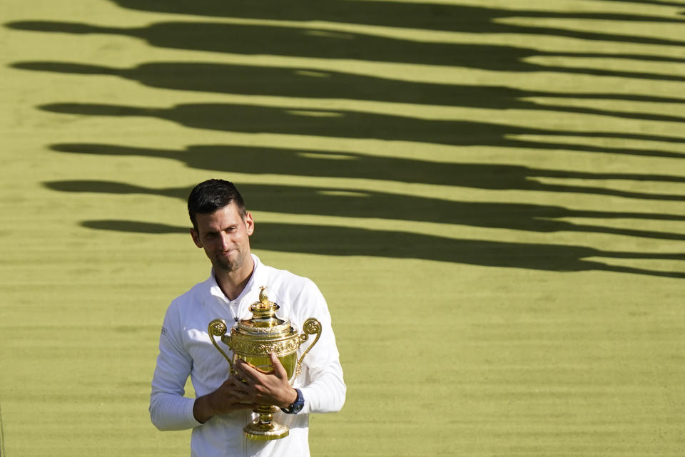 FILE - Serbia's Novak Djokovic holds the winners trophy as he celebrates after beating Australia's Nick Kyrgios to win the final of the men's singles on day fourteen of the Wimbledon tennis championships in London, Sunday, July 10, 2022. Prize money at Wimbledon this year will rise by more than 11% to 44.7 million pounds ($56.5 million). It is an increase of 17.1% on the last Wimbledon before the pandemic in 2019. The winners of the singles will each receive 2.35 million pounds ($3 million). Those earnings are back to the levels they were in 2019. (AP Photo/Gerald Herbert, File)