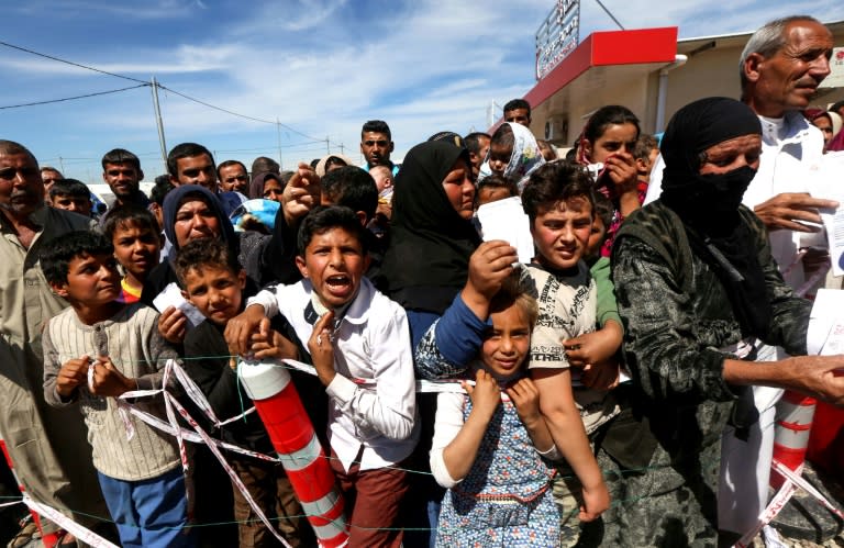 Iraqis, who fled the fighting for Mosul between government forces and the Islamic State group fighters, wait to receive food rations at al-Khazar camp on April 5, 2017