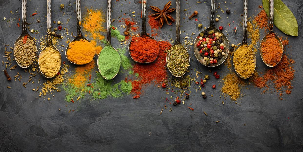 Various spices herbs on black concrete stone plate. Assortment of natural condiment. Top view with copy space.