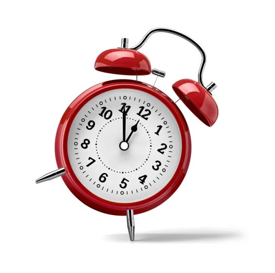 close up of a red clock on white background