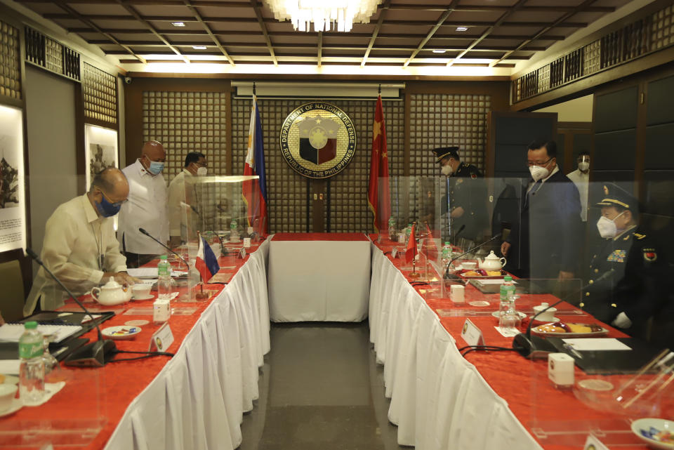 In this handout photo provided by the Department of National Defense Public Affairs Office (PAO), Philippine Defense Secretary Delfin N. Lorenzana, left, prepares to sit for a bilateral meeting with his Chinese counterpart General Wei Fenghe, right, at the Department of National Defense in Quezon city, Philippines, Friday Sept. 11, 2020. The two discussed ways in responding to the COVID-19 pandemic, revisited the 2004 Philippines-China Memorandum of Understanding (MOU) on Defense Cooperation and also issues on the South China Sea. (Department of National Defense PAO via AP)