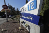 Flowers and candles rest near a sign for the Seattle Seahawks NFL football team headquarters Tuesday, Oct. 16, 2018, in Renton, Wash. in tribute to team owner Paul Allen, who died Monday, Oct. 15, 2018 in Seattle. (AP Photo/Ted S. Warren)