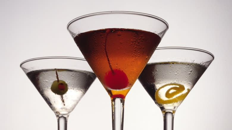 three cocktails in glasses on white background