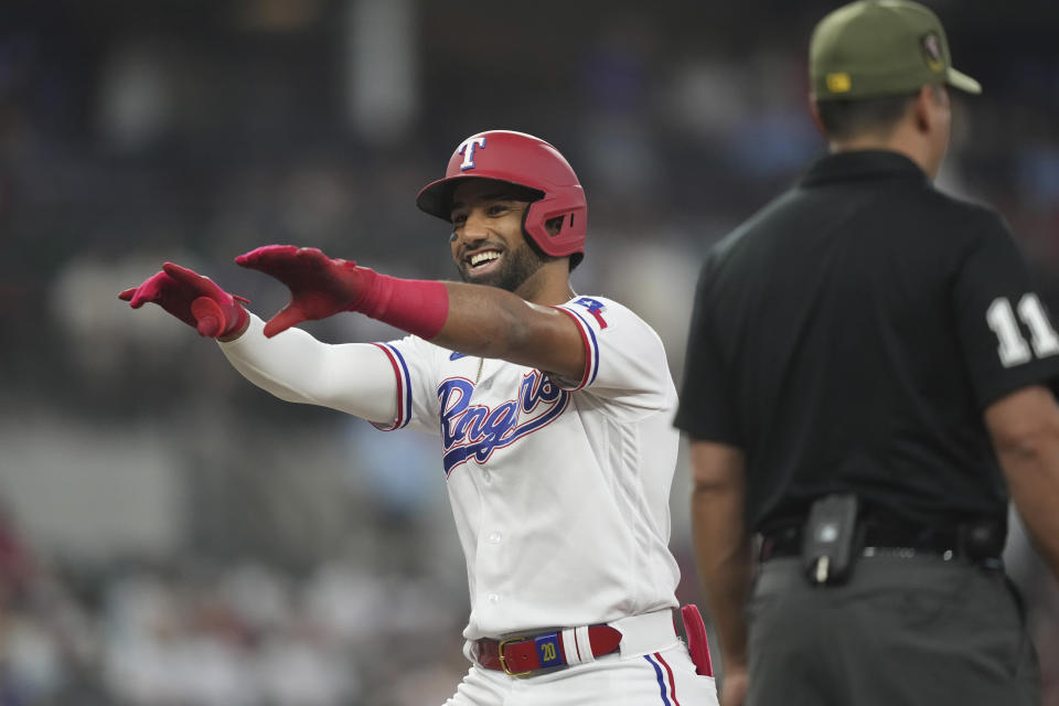 Texas Rangers' Ezequiel Duran, left, celebrates after his single that scored teammate Josh Jung during the first inning of a baseball game against the Colorado Rockies in Arlington, Texas, Saturday, May 20, 2023. (AP Photo/LM Otero)