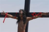 A penitent nailed to a cross grimaces during a re-enactment of the death of Jesus Christ on Good Friday in San Fernando, Pampanga in northern Philippines April 18, 2014. REUTERS/Erik De Castro