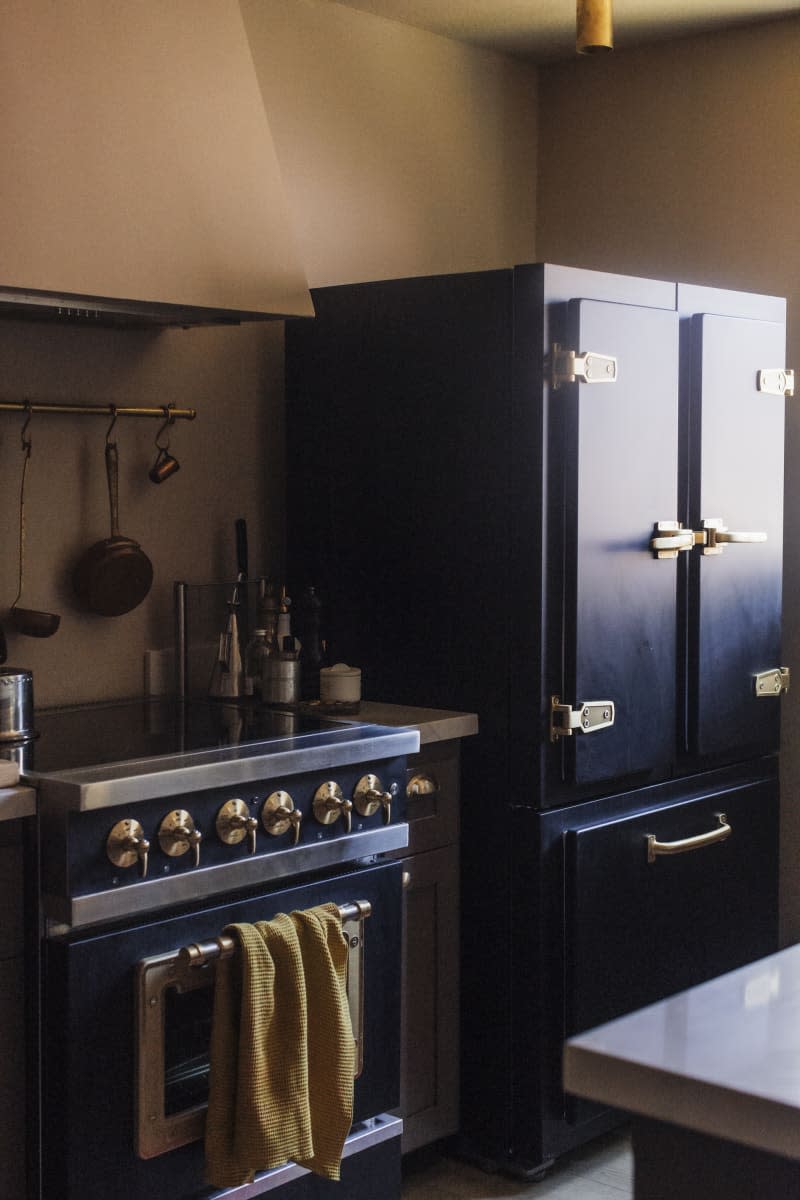 Beige kitchen with textured walls and deep blue cabinets and appliances