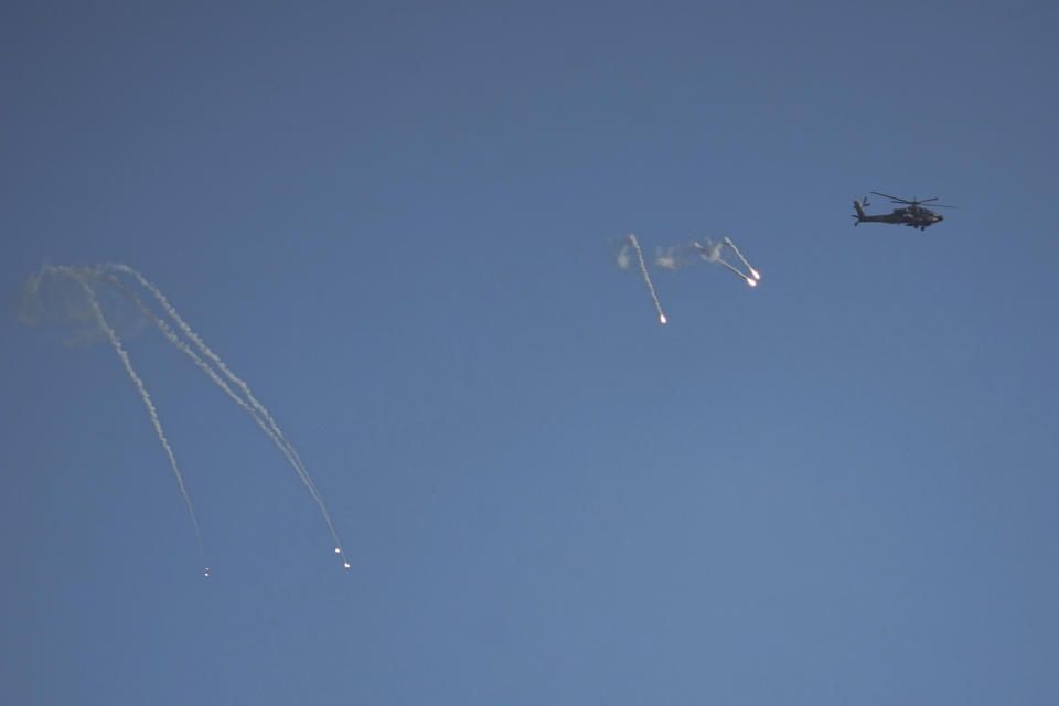 An Israeli Apache helicopter fires flares over the Gaza Strip, as seen from southern Israel, Sunday, Dec. 24, 2023. The army is battling Palestinian militants across Gaza in the war ignited by Hamas' Oct. 7 attack into Israel. (AP Photo/Ariel Schalit)