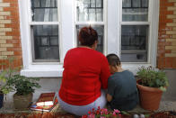 Eugenia Rodriguez shares a moment with her youngest son, Aaron, 6, while reading a children's book Friday, July 2, 2021, in Chicago's Little Village neighborhood. Rodriguez hasn't been eligible for insurance coverage after overstaying a visitor visa from Mexico. She used to wake up every two or three hours at night to check on her mother. Since getting health insurance through the Illinois program, her mother has all the medications she needs. (AP Photo/Shafkat Anowar)