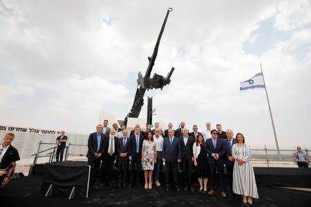 Israeli Prime Minister Benjamin Netanyahu poses for a picture with his cabinet ministers in front of a monument after a weekly cabinet meeting in the Jordan Valley, in the Israeli-occupied West Bank