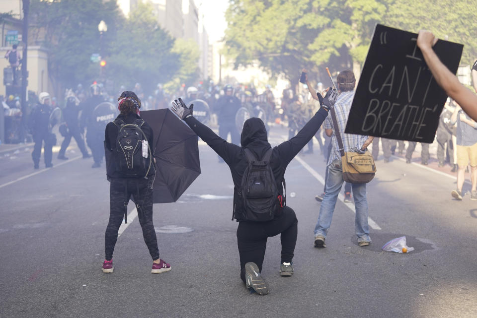 Manifestantes se arrodillan frente a una línea de policías durante una protesta por la muerte de George Floyd, el lunes 1 de junio de 2020, cerca de la Casa Blanca en Washington. Floyd murió después de ser inmovilizado por policías de Minneapolis. (AP Foto/Evan Vucci)