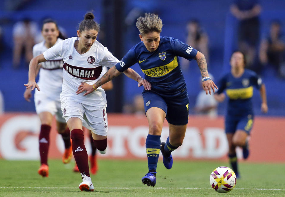 Boca Juniors' Yamila Rodriguez, right, fights for the ball with Lanus's Vanina Garcia during a Superliga women's soccer tournament in Buenos Aires, Argentina, Saturday, March 9, 2019. The women competed in one of Argentina's most famous stadiums on Saturday, a milestone for the female players who are fighting for the same rights as male soccer players in the country's most popular sport. (AP Photo/Natacha Pisarenko)