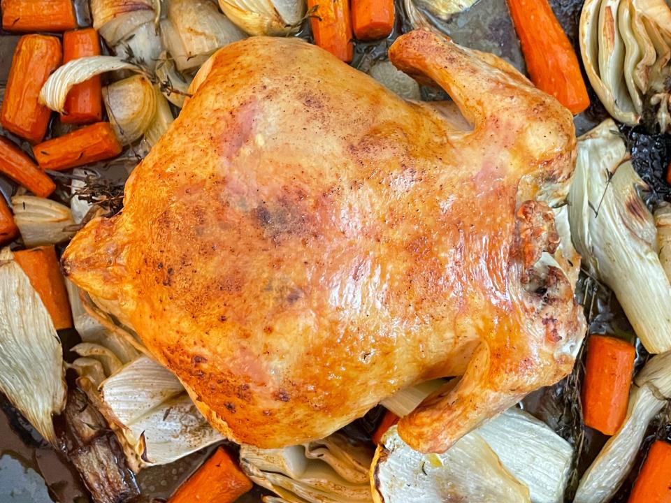 overhead shot of chicken in a roasting pan with vegetables