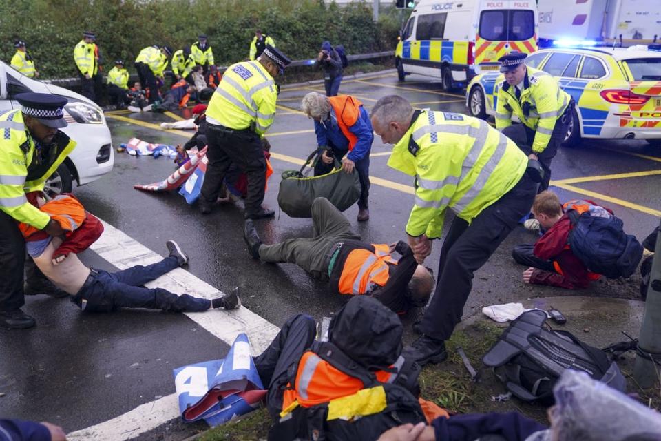 Police officers detain a protester occupying a roundabout near the M25 (PA) (PA Archive)