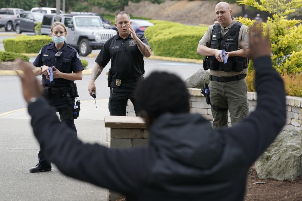 FILE - Ken Westphal, center, an officer with the Lacey Police Dept. and an instructor at the Washington state Criminal Justice Training Commission, works with cadets LeAnne Cone, of the Vancouver Police Dept., and Kevin Burton-Crow, right, of the Thurston Co. Sheriff's Dept., during a training exercise Wednesday, July 14, 2021, in Burien, Wash. (AP Photo/Ted S. Warren, File)