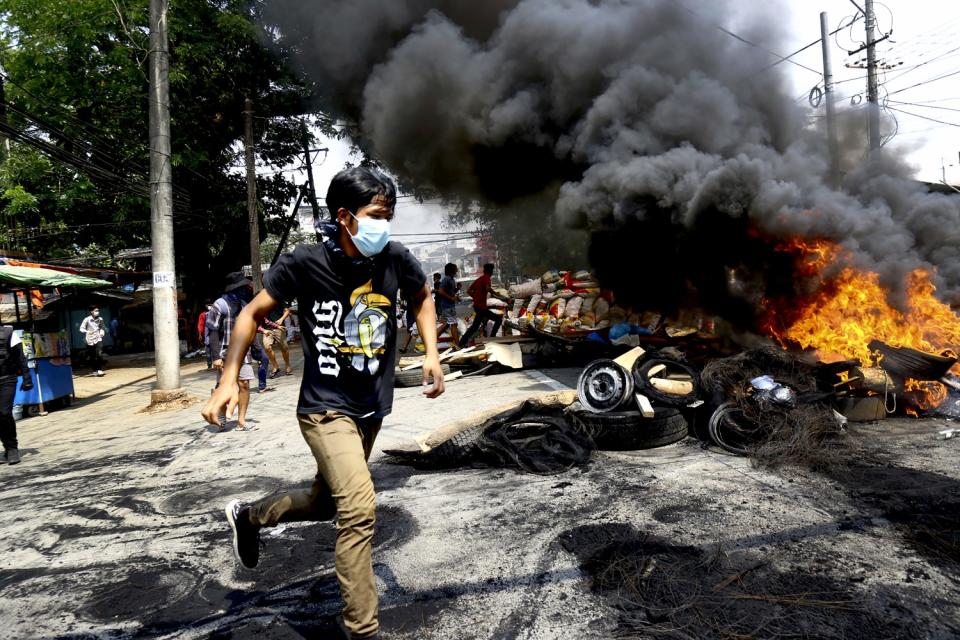 A protester near burning debris.